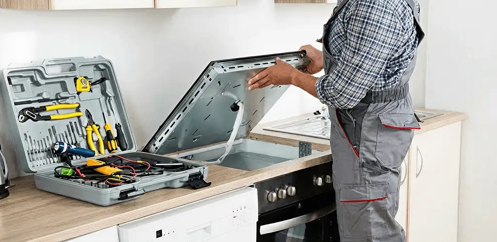 Handyman repairing a cooktop and checking wiring connections in Cincinnati, OH