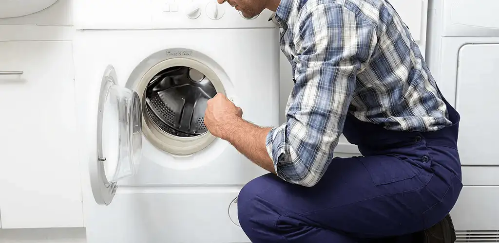 Handyman inspecting a dryer drum and internal parts for repair in Cincinnati, OH