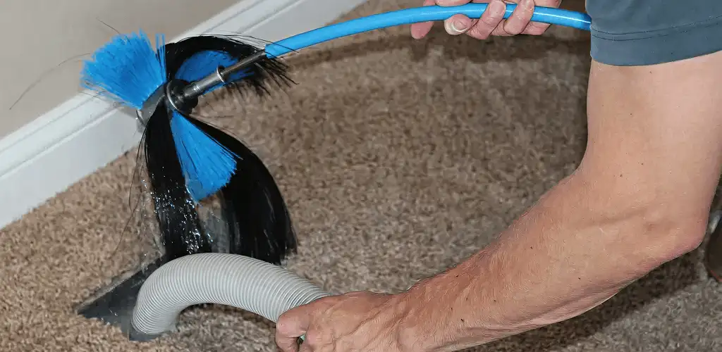 Dryer vent cleaning technician brushing lint from a vent line in Cincinnati, OH