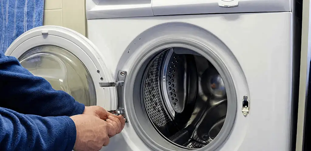 Washing machine repair handyman checking a front-load washer door and latch in Cincinnati, OH