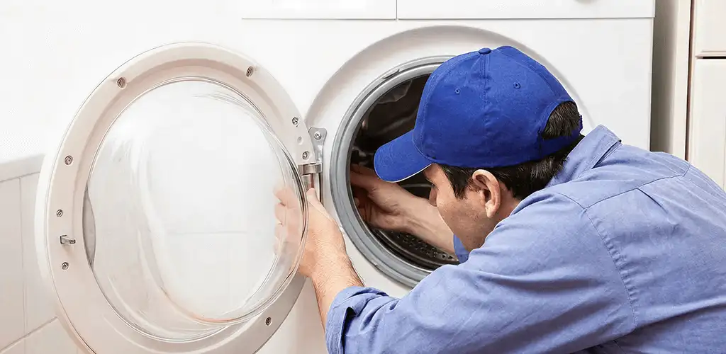 Washing machine repair handyman inspecting a front-load washer drum in Cincinnati, OH